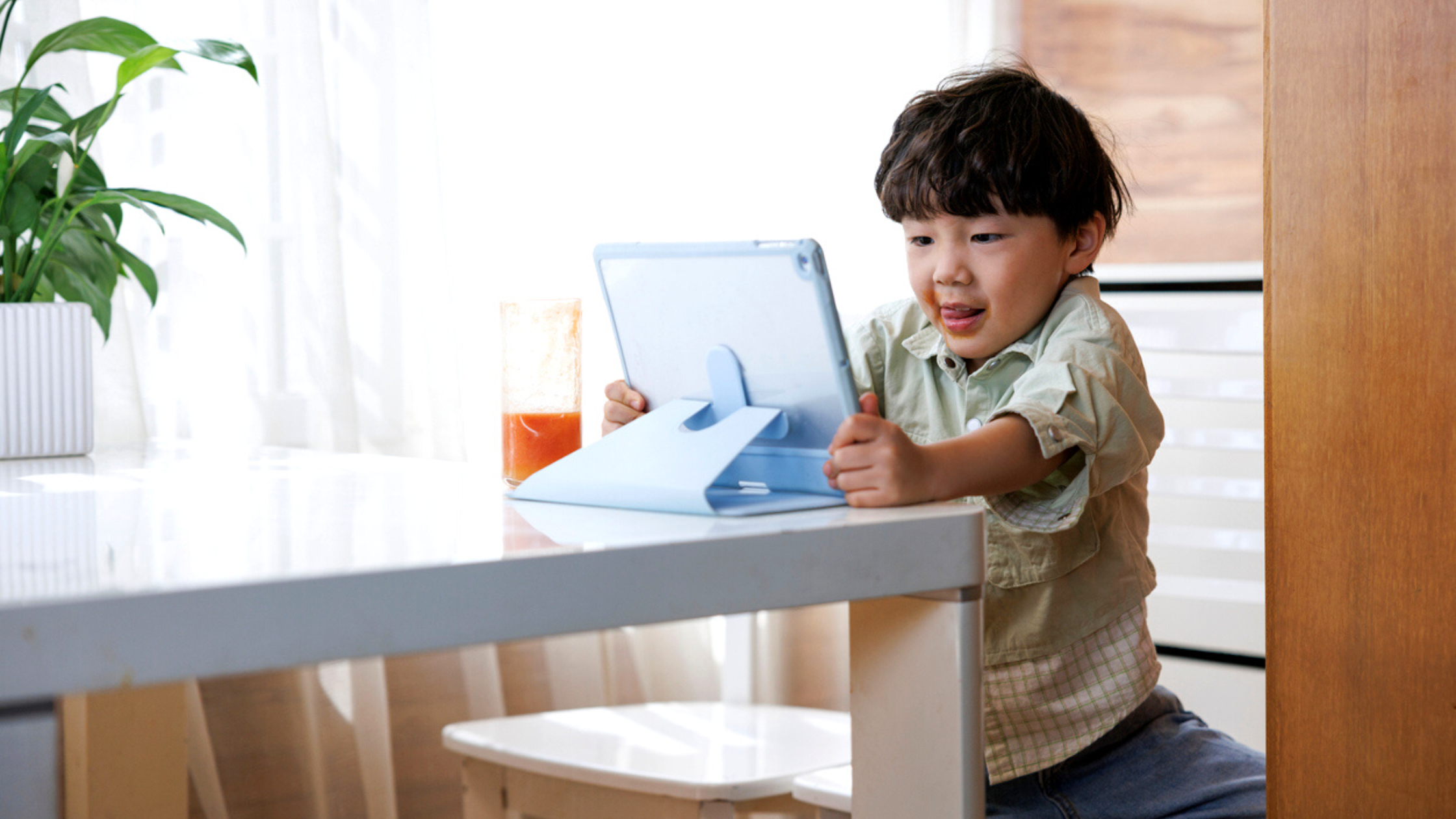 A little boy enjoying his screen time while using the tablet.